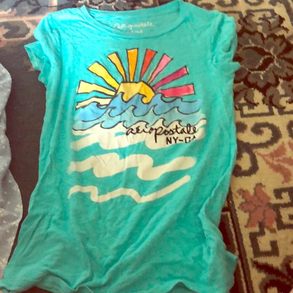 Blue shirt with sun set and waves